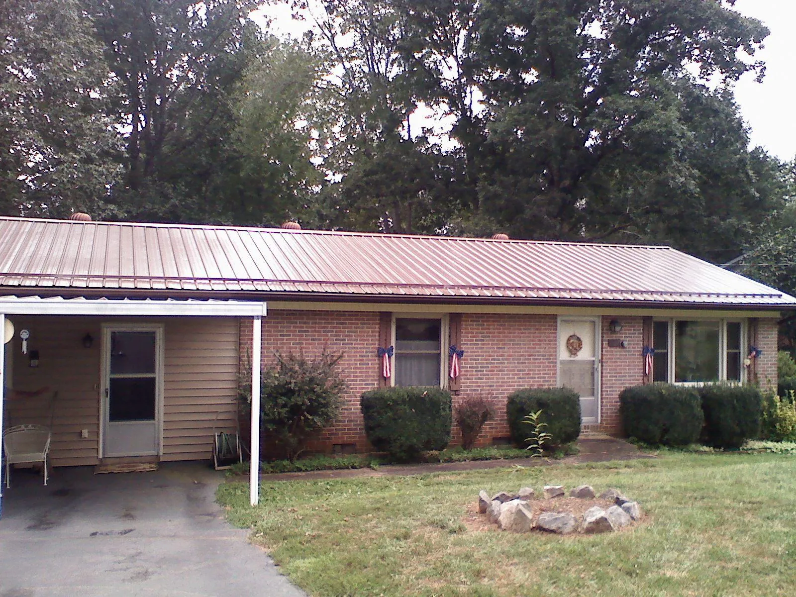 Bronze metal roof and carport on a brick ranch home — Roof Repair work by our crew in Como